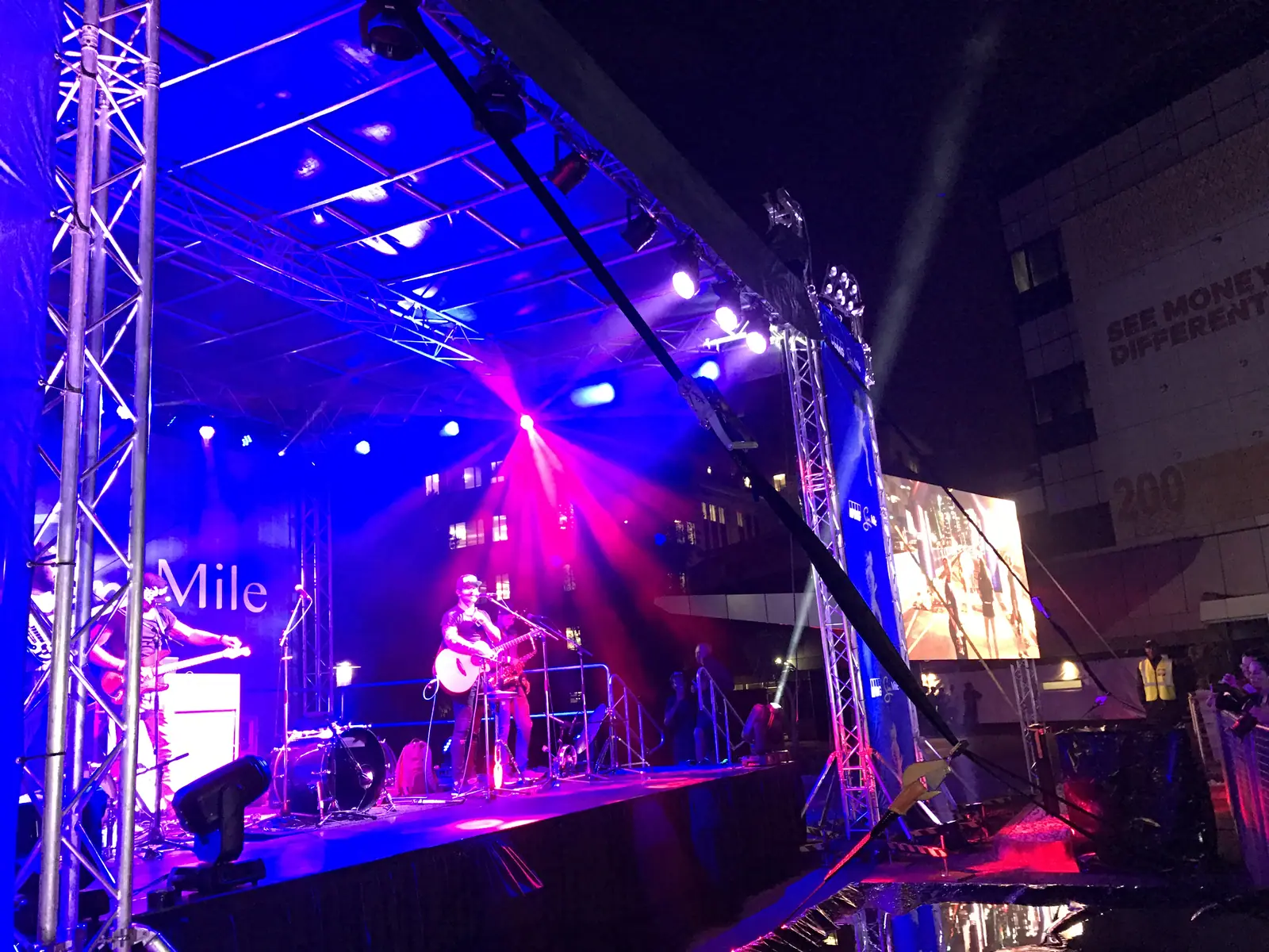 Band performs on the lit KPMG Sun Mile stage at night