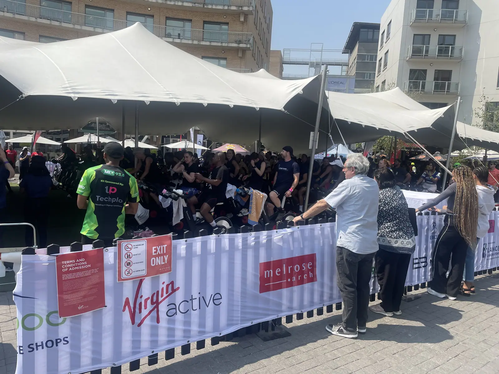 Rows of spinning bikes under a stretch tent at Melrose Arch