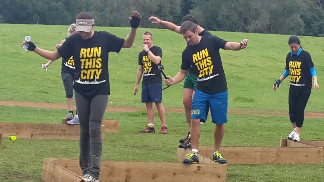 Competitors in Run This City shirts take on a balance obstacle