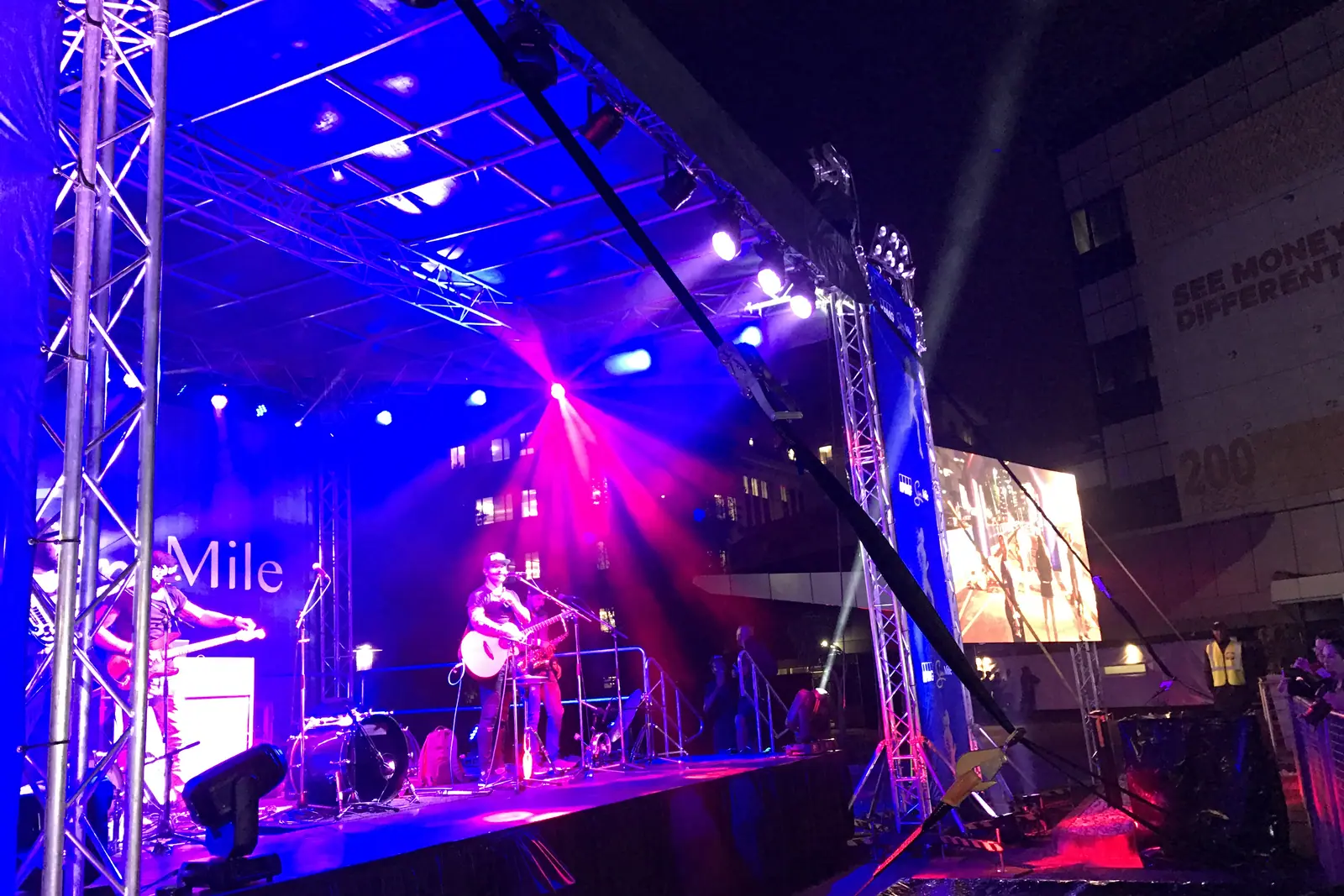 Band performing on a lit stage at the KPMG Sun Mile concert in Sandton